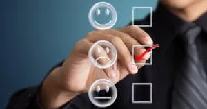A man in a business suit is pointing to a smiley face, indicating a successful survey conversion rate.