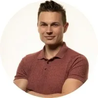 A man in a red shirt with his arms crossed.