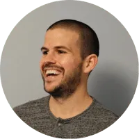 A smiling man wearing a gray shirt while representing ecommerce brands.